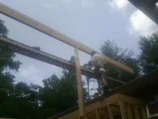 Carpenter setting a ridge beam over a new addition frame — Ice Dam Removal by Roofing Brothers in Saxonburg