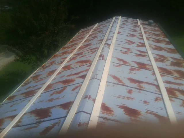 Rusted metal roof panels with new wood purlins before replacement — Storm Damage Roof Repair in Saxonburg by Roofing Brothers