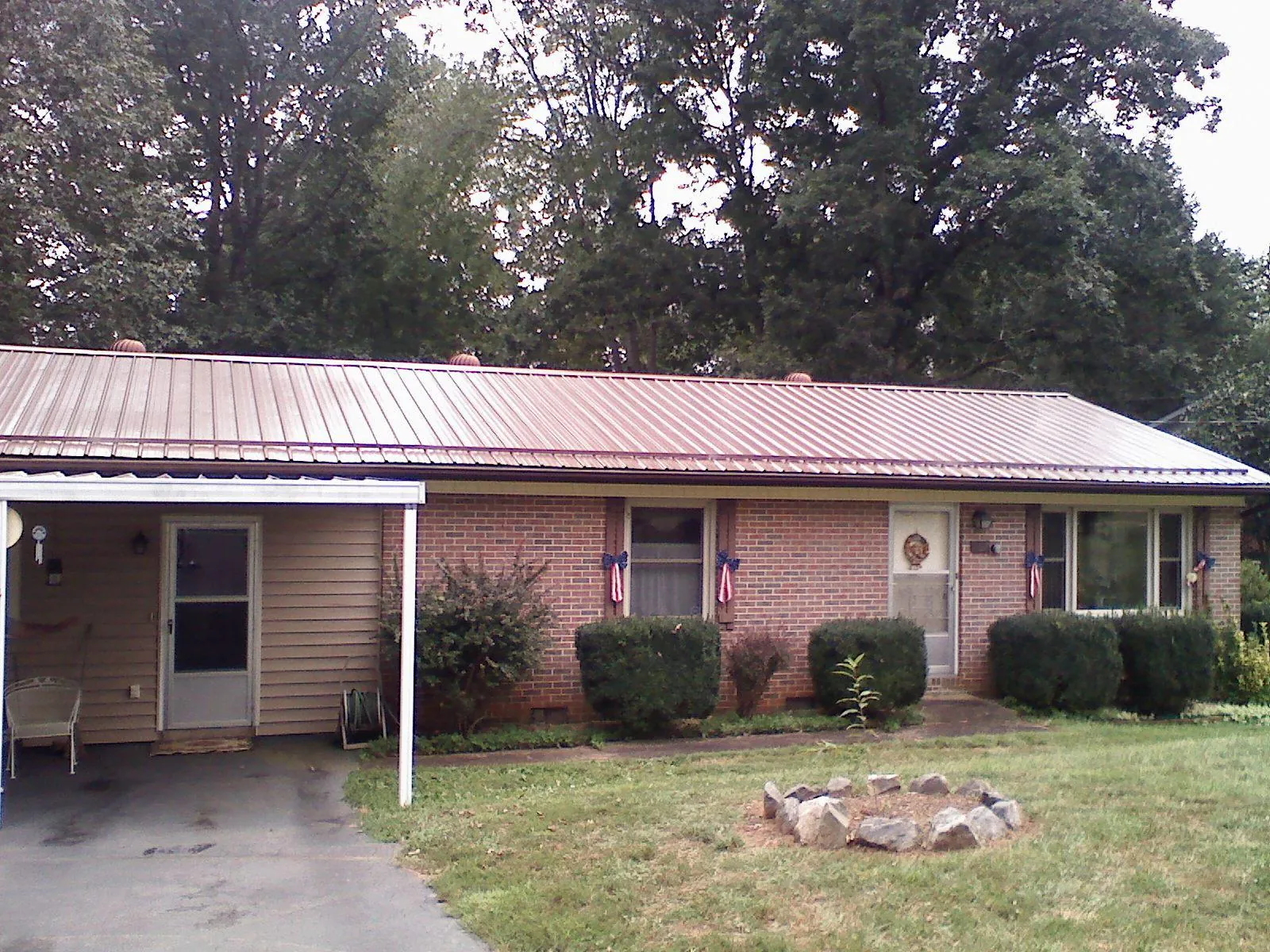 Bronze metal roof and carport on a brick ranch home — Roof Repair work by our crew in Saxonburg